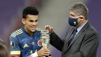 Conmebol General Secretary Jose Astigarraga, right, gives to Colombia's Luis Diaz the best player of the match trophy after beating Peru 3-2 in the Copa America third-place match.