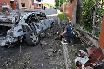 De-miners examine the site after a rocket attack in Kharkiv. AFP