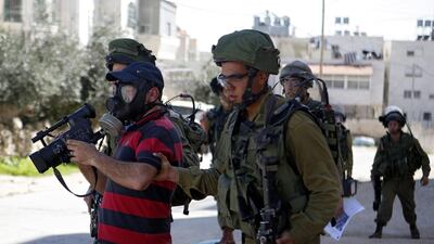 An Israeli soldier detains a journalist during a demonstration at Kiryat Arba settlement near Hebron on February 26, 2016. Abed Al Hashlamoun / EPA