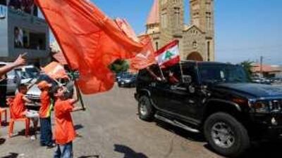 Supporters of the Lebanese Christian opposition leader Michel Aoun wave their party flags in Kahaleh village in Mount Lebanon yesterday.