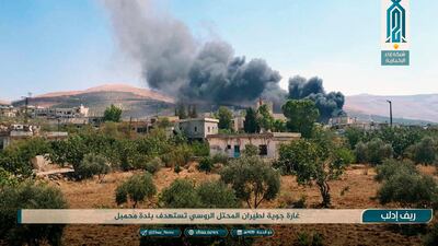 Smoke rises over buildings hit by air strikes, in Mahambal village, in the north Syria province of Idlib. Ibaa News Agency, via AP
