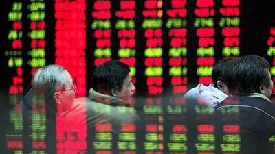 Investors watch the stock trading board at a brokerage in Shanghai. Fitch has warned of a systemic risk from the "Wild West atmosphere" in Chinese financial markets. Qilai Shen / Bloomberg News