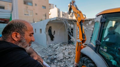 A relative of the Palestinian Shalalda family watches as an excavator they hired is used to demolish their family home in East Jerusalem. AFP