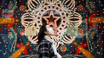 A woman wearing a protective face mask walks past Christmas decorations at Ginza shopping district in Tokyo, Japan. Reuters