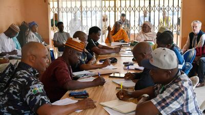 An EU observer, back right, watches Independent National Electoral Commission officials recording election results in Yola, Nigeria. AFP