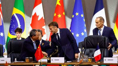France's President Emmanuel Macron shakes hands with Chinese Premier Li Qiang. Reuters