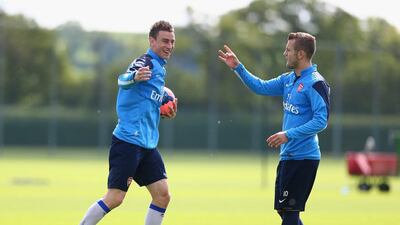Laurent Koscielny and Jack Wilshere of Arsenal share a joke during Wednesday's training session for the FA Cup final. Clive Mason / Getty Images / May 14, 2014