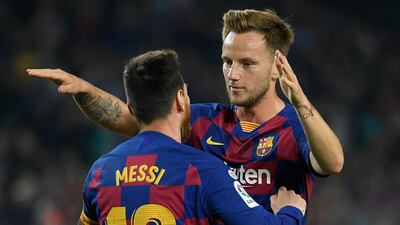 Barcelona's Croatian midfielder Ivan Rakitic (R) congratulates Barcelona's Argentine forward Lionel Messi for his second goal during the Spanish league football match between FC Barcelona and Real Valladolid FC at the Camp Nou stadium in Barcelona on October 29, 2019. / AFP / LLUIS GENE