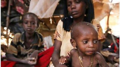 Severely malnourished Samon Hassan Yarow, 8 months, is held by his mother Owliyo Adan Ibrahim in their makeshift shelter at Ifo camp in Dadaab town, north-eastern Kenya.