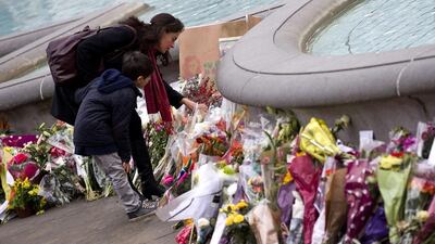 People lay floral tributes for late South African former president Nelson Mandela around the fountain in Trafalgar Square in central London. Justin Tallis / AFP