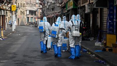 Health workers in protective gear prepare to spray disinfectant in a blocked off area in Shanghai's Huangpu district, after residents were evacuated following the detection of a few cases of COVID-19 coronavirus in the neighbourhood. AFP