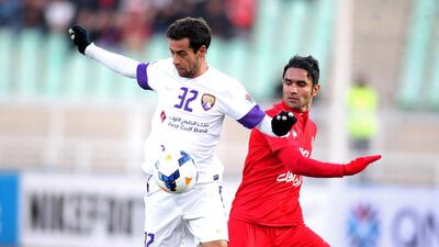 Al Ain’s Alex Brosque, left, controls the ball despite pressure from Tractor Sazi’s Morteza Asadi during their match on Tuesday night in Iran. AFP