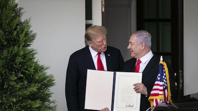 Benjamin Netanyahu, Israel's prime minister, holds up a signed proclamation while speaking with President Donald Trump. Bloomberg