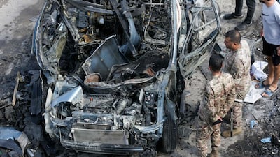 Lebanese security forces inspect a car destroyed in an Israeli drone attack in the southern village of Zebdine. The attack killed Hassan Atwi, a Hezbollah member blinded in last year's pager bombings, and his wife, Zainab Raslan, as they went to collect their children from school. AFP