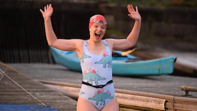 A swimmer reacts as she jumps into the water for a 'dawn dip' in the West Reservoir outdoor swimming lake in east London . AFP