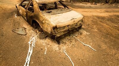 A scorched car rests next to a residence leveled by the Detwiler fire near Mariposa. Noah Berger / AP Photo