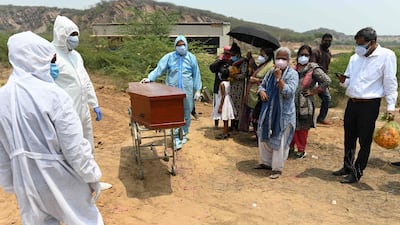Employees of Michael Undertakers and Ambulance Services, seen wearing personal protective equipment suits, join mourners at the burial of a Covid-19 coronavirus victim at a Christian cemetery in Pali, a village near Faridabad. AFP