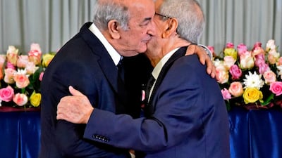 Algerian President Abdelmadjid Tebboune, left, embraces the interim president Abdelkader Bensalah during the formal swearing-in ceremony in Algiers . AFP