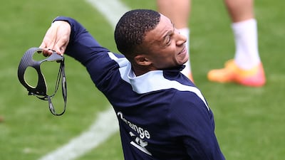Mbappe celebrates scoring by throwing away his mask. AFP