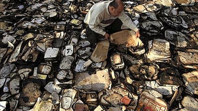 A book restorer sifts through burnt and smoke-damaged books at the Institute of Egypt in Cairo after the centre caught fire during recent clashes between security forces and protesters.