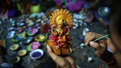 A child, studying under the guidance of Initiative for Viable Education (IVE) for underprivileged children, paints an idol of Goddess Laxmi as he prepares it ahead of Diwali festival in Amritsar, India. Raminder Pal Singh / EPA