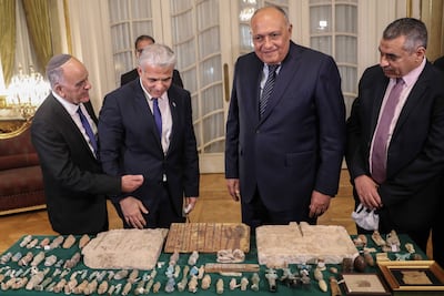 Israeli Foreign Minister Yair Lapid, second from left, and Egyptian Foreign Minister Sameh Shoukry, second from right, stand near by several Egyptian artefacts that were stolen and smuggled to Israel. They were attending a handover ceremony during their meeting in Cairo on December 9. EPA