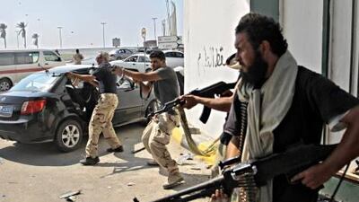 Libyan rebel fighters fire towards forces loyal to Muammar Qaddafi during fierce gunfire in downtown Tripoli, Libya on Monday.