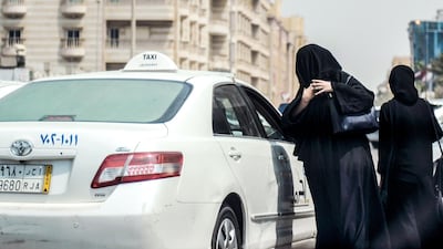 A Saudi woman prepares to get into a taxi on a main street in Jeddah. AFP / Amer Hilabi