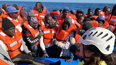 Rescued migrants are assisted by Sea-Watch rescue ship's personnel in the Mediterranean Sea, Jan. 19, 2019. AP