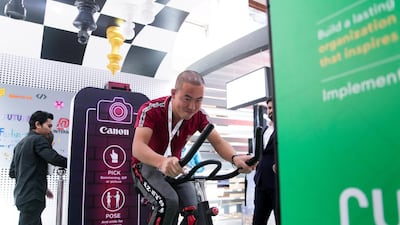 A man cycles to generate power at Dubai Internet City booth. Reem Mohammed / The National