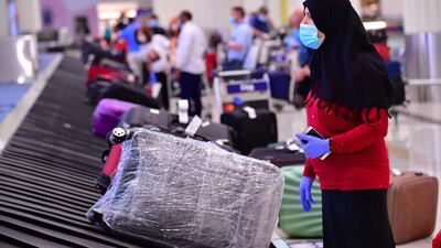 A tourist waits for her luggage at Dubai airport. AFP