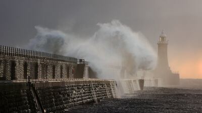 Waves crash over the Tynemouth pier lighthouse at the mouth of the river Tyne in North East England. PA