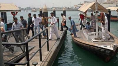 People disembark from an abra at the Bur Dubai station on the Dubai Creek