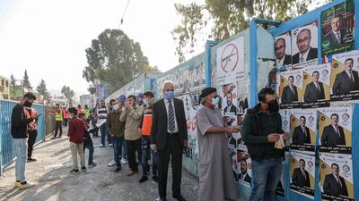 Voters, mask-clad due to Covid-19, queue outside a polling station in Al Baqaa camp for Palestinian refugees north of Amman. AFP