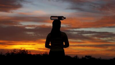 A Rohingya migrant woman carries a bottle of drinking water inside a temporary compound for refugees in Kuala Cangkoi village in Lhoksukon, Indonesia’s Aceh Province on May 17. Beawiharta/Reuters