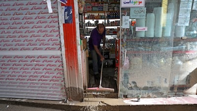 A shopkeeper clears up after the flood. AP Photo