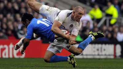 England's Mike Tindall, top, is tackled by Italy's Luciano Orquera during their Six Nations international rugby union match at Twickenham stadium, London. Tindall announced his retirement over Twitter on Tuesday, July 15, 2014. AP Photo/Tom Hevezi