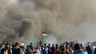 Protesters wave the Palestinian flag during clashes with Israeli security forces near the border fence east of Gaza City on December 15, 2017. Mohammed Abed / AFP