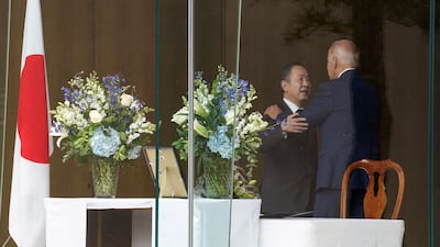 Mr Biden is embraced by Mr Koji. Reuters