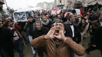 Mourners chant slogans as they carry coffins of victims killed by a suicide bombing on Thursday that targeted men volunteering to join the government's fight against Al Qaeda-linked militants in Anbar province. Mushtaq Muhammed / Reuters