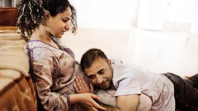 KHANAQIN, IRAQ: Ali Arkady puts his head on the belly of his pregnant wife, Marwa.