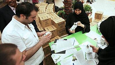 Sumaya al Obadilidli, right, gives out one of 40,000 energy-saving light bulbs at Marina Mall.