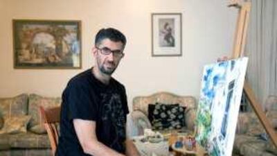 Nabeel al Mehairbi poses at home with one of his post-Impressionistic works, which were inspired by Jazirat al Hamra.