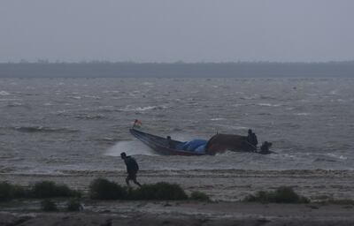 Fishermen attempt to bring their boat back to shore during high tide as preparations are made for Cyclone Dana to make landfall in Bhadrak, Odisha. Reuters