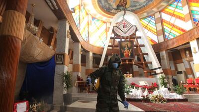 An Iraqi civil defence team sprays disinfectant inside the Our Lady of Salvation Church in central Baghdad as part of measures to contain the spread of the Covid-19 coronavirus. AFP