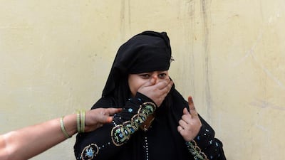 Indian voter laughs as she shows her finger with the election ink mark outside a polling station in New Delhi. Chandan Khanna / AFP Photo