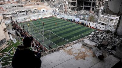 Palestinians watch a game of five-a-side football on a pitch surrounded by the rubble of Gaza city. AFP