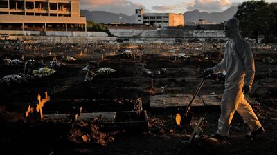 A funeral worker wearing protective clothing as a preventive measure against the novel coronavirus, Covid-19, walks through Caju cemetary in Rio de Janeiro, Brazil. AFP