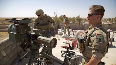 In this Sugust 20, 2017 photo, US army soldiers stand next to a guided-missile launcher in the village of Abu Ghaddur, east of Tal Afar, Iraq. Balint Szlanko / AP