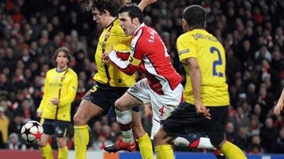 Barcelona's Spanish defender Carles Puyol, left, vies with Arsenal's Spanish midfielder Cesc Fabregas.